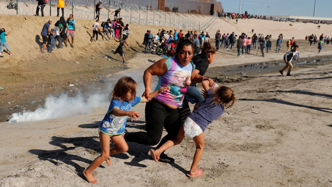 A Honduran mother and children run away from tear gas November 25 in Tijuana, Mexico.