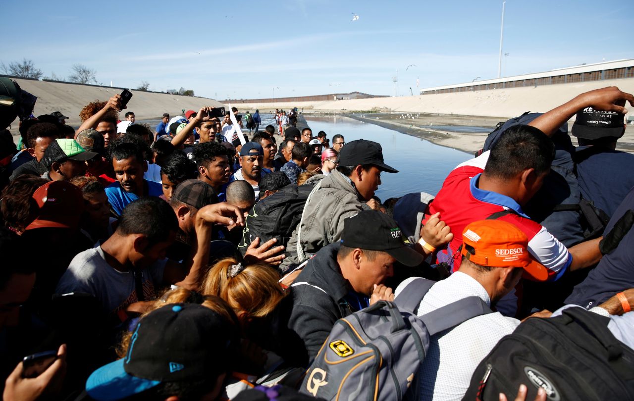 Migrants make their way to cross the Tijuana River near the border wall on November 25. Many of the migrants who cross Mexico in hopes of reaching the US are<a href="http://www.cnn.com/2018/06/20/americas/separated-families-countries-snapshots/index.html" target="_blank"> fleeing rampant violence or extreme poverty</a>. 
