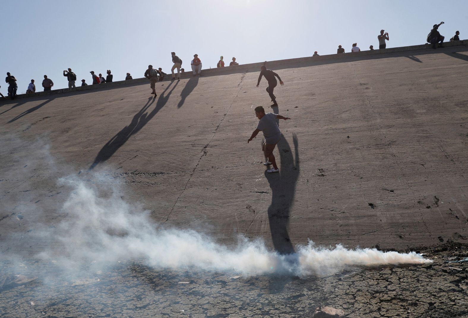 Migrants run away from tear gas on Sunday, November 25. Tijuana police said they arrested 39 people in connection with the attempt to cross the Mexico-US border illegally