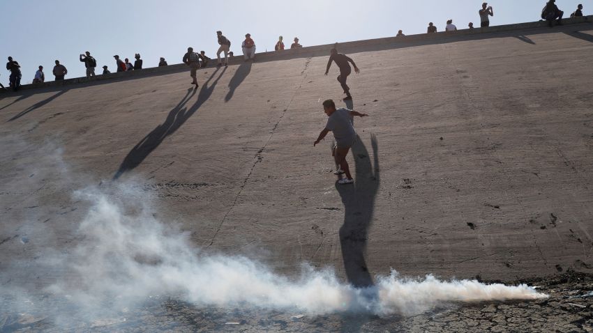 Migrants, part of a caravan of thousands traveling from Central America en route to the United States, run away from tear gas thrown by the U.S. border control near the border wall between the U.S and Mexico in Tijuana, Mexico November 25, 2018. REUTERS/Kim Kyung-Hoon