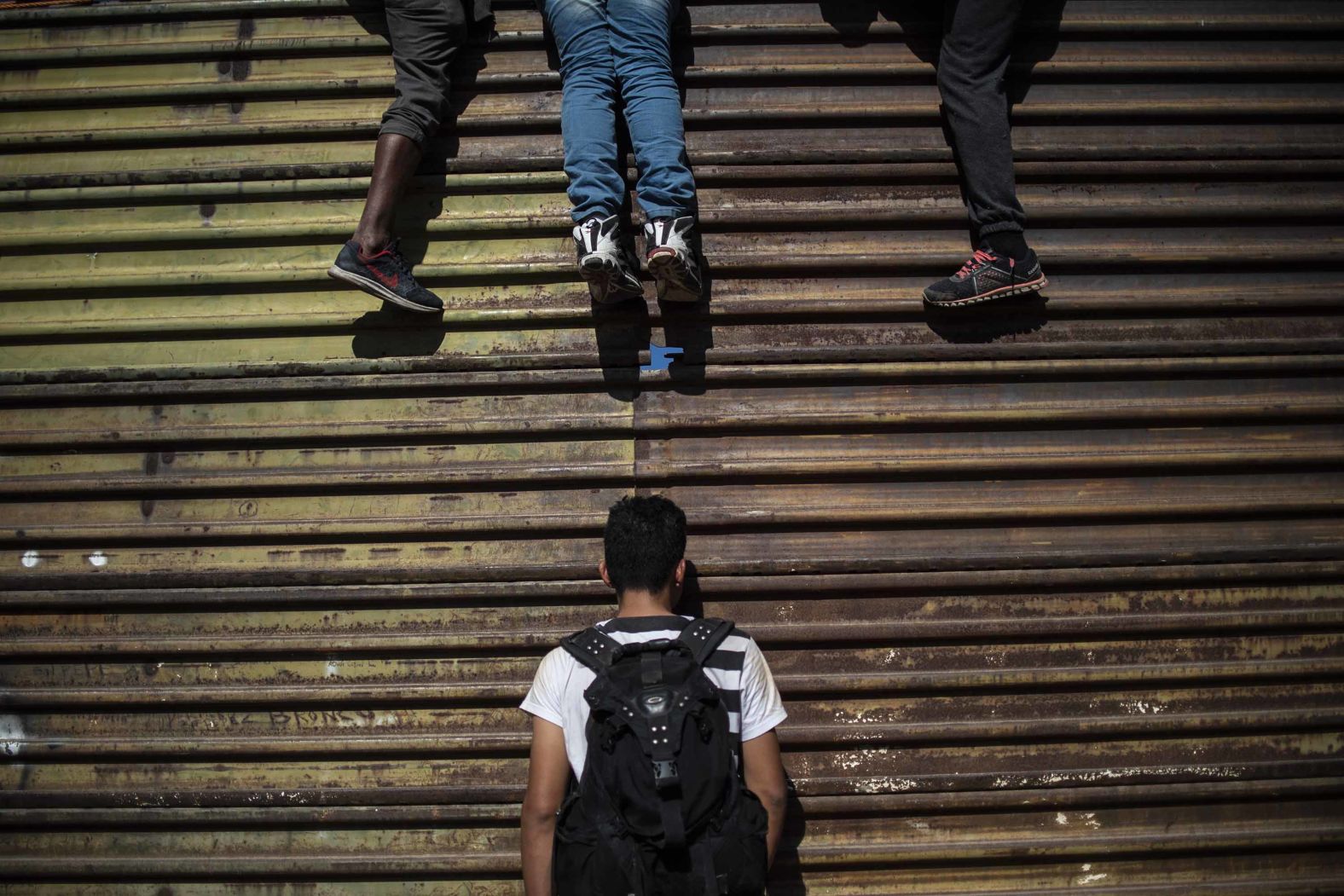 Migrants try to climb the border fence.