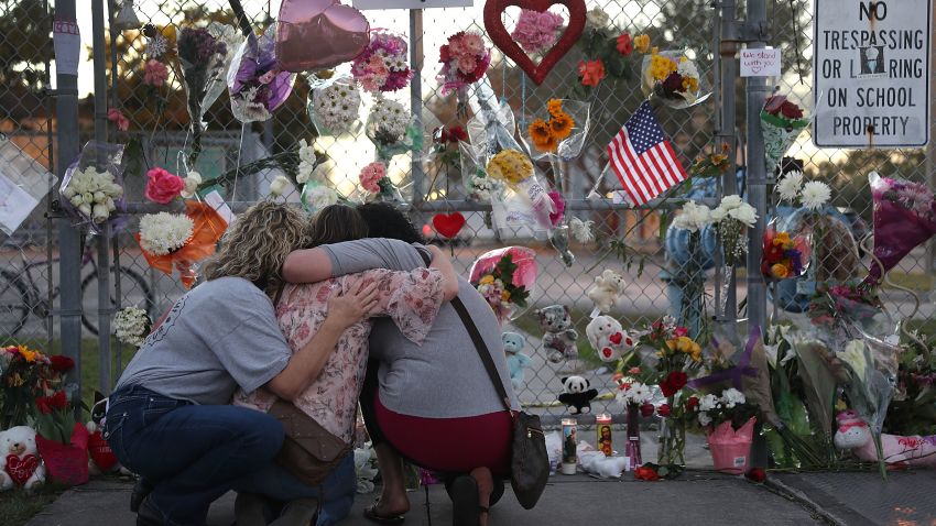 PARKLAND, FL - FEBRUARY 18: Shari Unger, Melissa Goldsmith and Giulianna Cerbono (L-R) hug each other as they visit a makeshift memorial setup in front of Marjory Stoneman Douglas High School on February 18, 2018 in Parkland, Florida. Police arrested and charged 19 year old former student Nikolas Cruz for the February 14 shooting that killed 17 people.