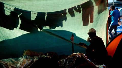 A migrant drinks water as he waits in the shelter, where more than 5,000 migrants are living.