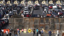 TIJUANA, MEXICO - NOVEMBER 25:  People attempting to cross in the U.S. look on as the San Ysidro port of entry stands closed at the U.S.-Mexico border on November 25, 2018 in Tijuana, Mexico. Migrants circumvented a police blockade as they attempted to approach the El Chaparral port of entry and U.S. Customs and Border Protection temporarily closed the two ports of entry on the border with Tijuana in response. Around 6,000 migrants from Central America have arrived in the city with the mayor of Tijuana declaring the situation a 'humanitarian crisis'.  (Photo by Mario Tama/Getty Images)