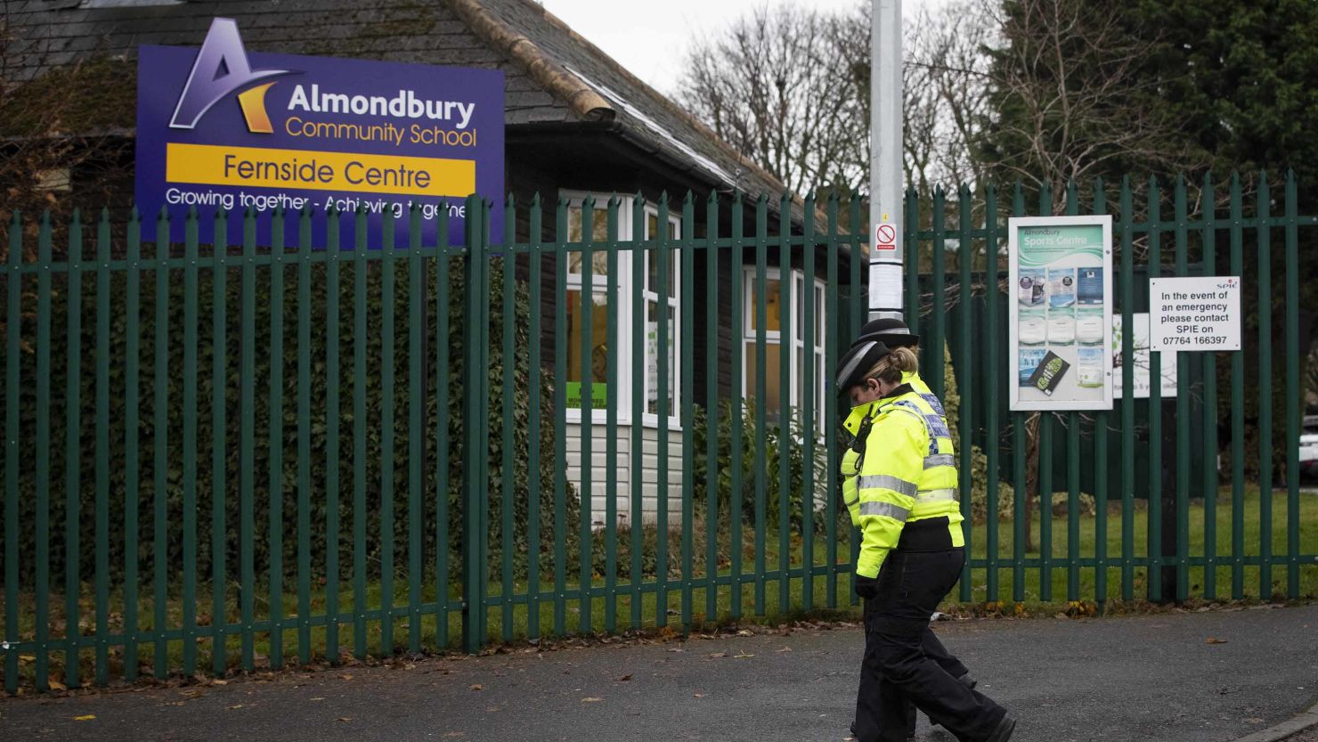 Officers on Wednesday passing the Almondbury Community School in Huddersfield, England, where police are investigating the assault of a Syrian boy.