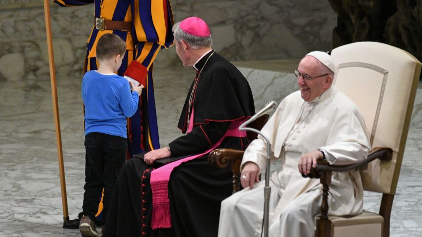 Pope Francis (R) laughs as a boy who jumped from the audience onto the stage, interacts with a Swiss Guard during the weekly general audience on November 28, 2018 in Paul VI hall at the Vatican. (Photo by Vincenzo PINTO / AFP)        (Photo credit should read VINCENZO PINTO/AFP/Getty Images)