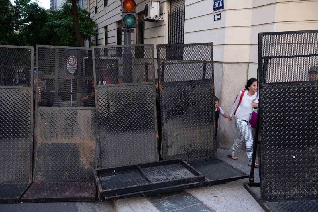 Residents walk past barriers in a security zone in downtown Buenos Aires.  