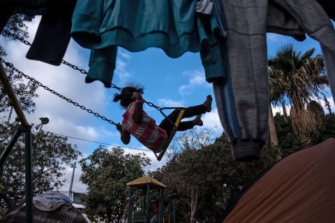 A girl rides a swing at the shelter.