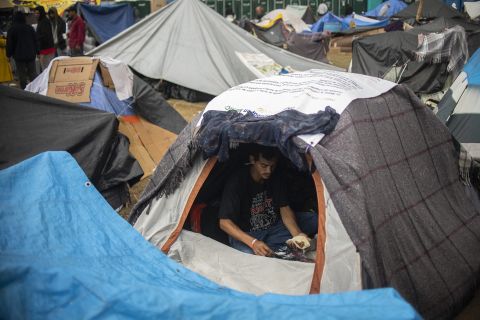 A man eats inside a tent.