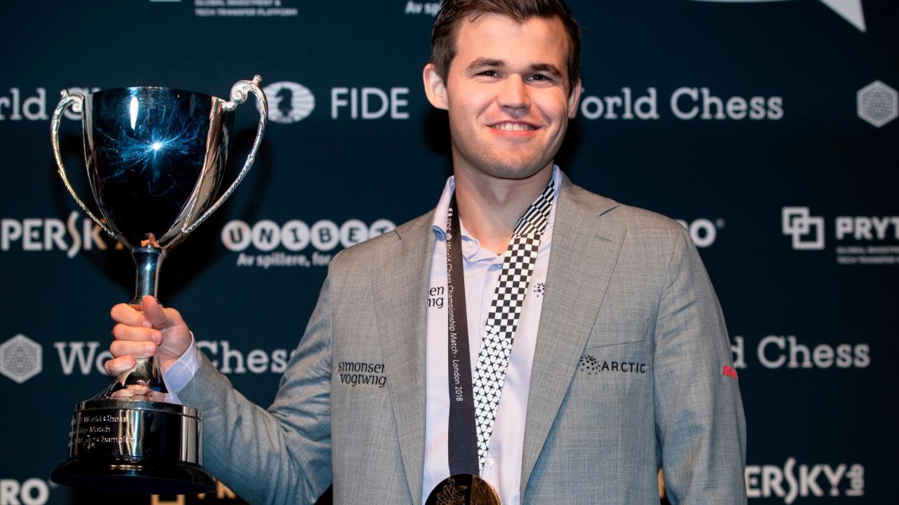 Carlsen holds his trophy up after beating Fabiano Caruana to regain his World Chess Championship title on November 28, 2018 in London.