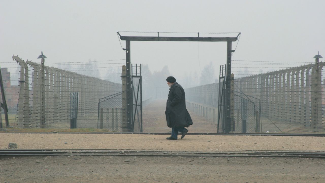 Glassman walks at the gates of Auschwitz, a Nazi concentration camp, where he said he heard souls' voices clamoring to be remembered. Photograph by Peter Cunningham. 