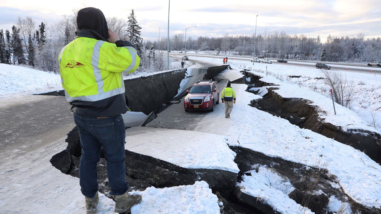 A stranded vehicle sits on a collapsed roadway near the Anchorage airport after the 7.0 earthquake. 