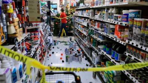 An employee walks past a damaged aisle at an Anchorage True Value hardware store.  