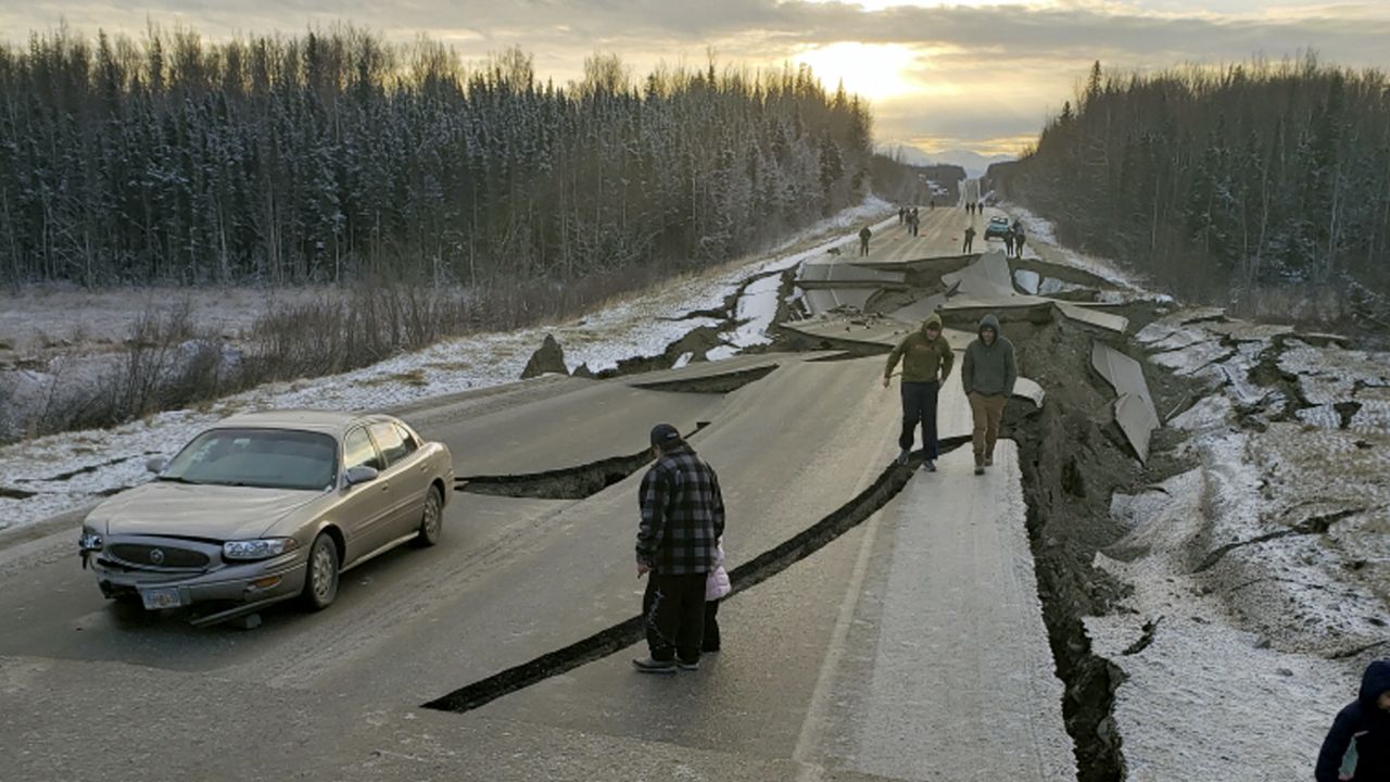 In this photo provided by Jonathan M. Lettow, people walk along Vine Road after the earthquake. 