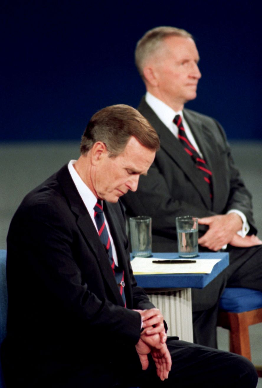 Bush checks his watch during a 1992 presidential debate with Ross Perot, right, and Bill Clinton. The memorable moment was interpreted as the President being out of touch.