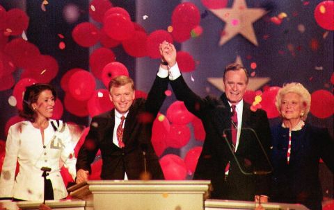 Bush and Vice President Dan Quayle join hands at the 1992 Republican National Convention in Houston. They are joined by their wives, Marilyn Quayle and Barbara Bush.