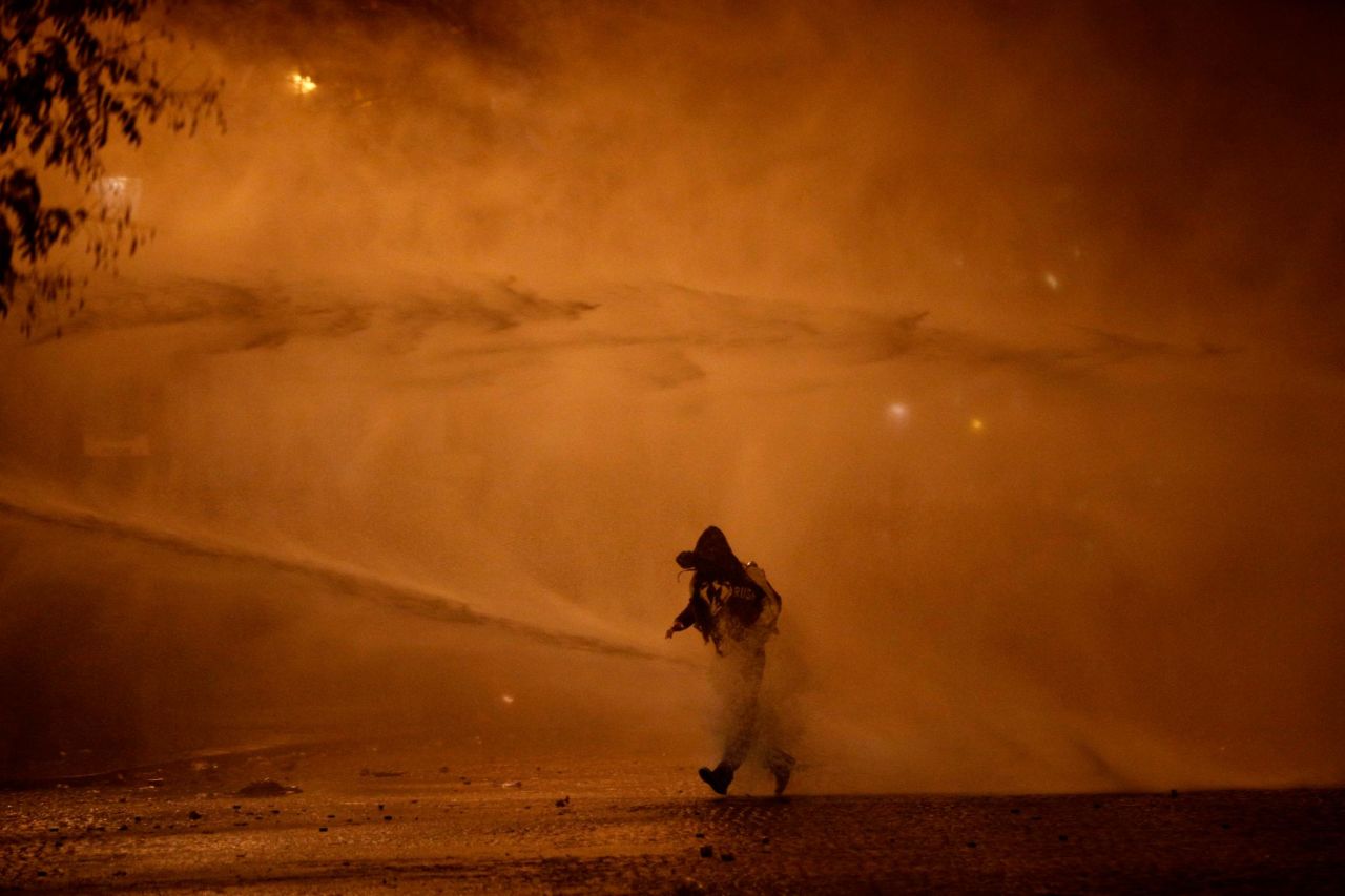 A demonstrator leaves as water cannons evacuate the Place de l'Etoile on December 1.