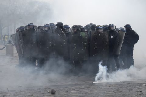 Riot police officers stand in position during clashes with demonstrators on December 1.