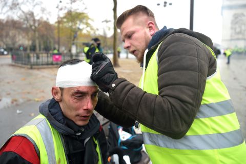 A demonstrator treats a wounded man during a protest where police and demonstrators clashed, injuring dozens on December 1.