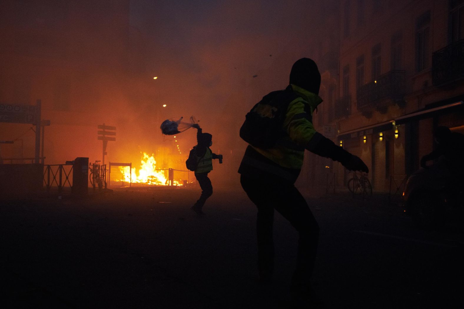 Protesters throw objects at riot police on Saturday, December 1, during a demonstration that turned violent when protestors clashed with police in Paris.