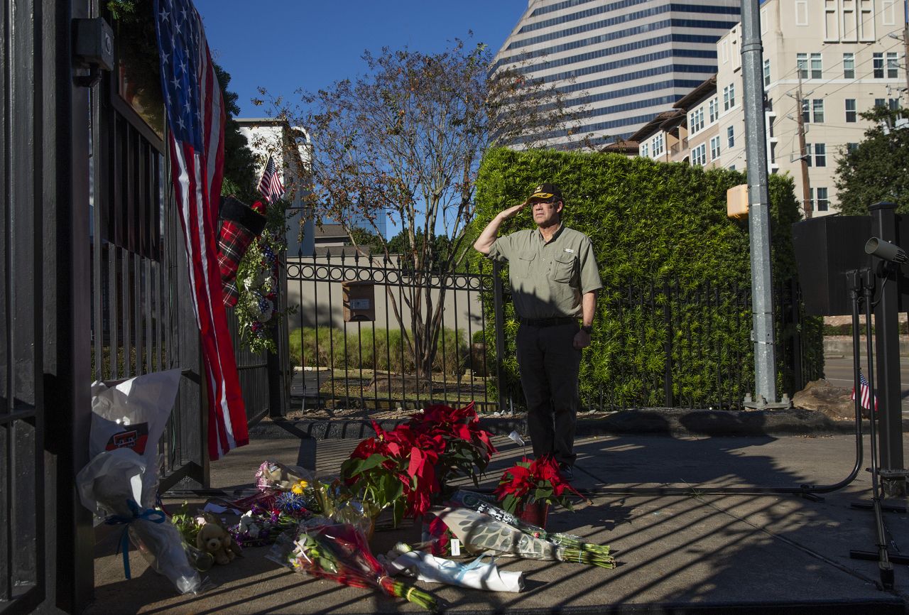 A veteran salutes Bush at a memorial outside Bush's home in Houston on December 1.