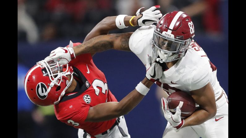 Alabama tight end Irv Smith Jr. grabs Georgia defensive back Tyson Campbell during the first half of the Southeastern Conference championship game on Saturday, December 1, in Atlanta. The top-ranked Crimson Tide defeated the Bulldogs 35-28.