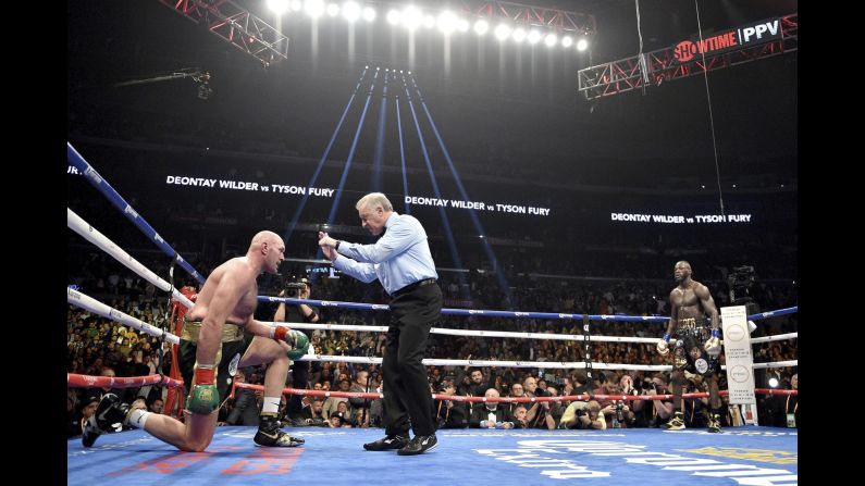 Tyson Fury kneels after getting knocked down by Deontay Wilder in the 12th round of the WBC Heavyweight Championship bout at the Staples Center on Saturday, December 1, in Los Angeles. The fight was ruled a split draw after 12 rounds.