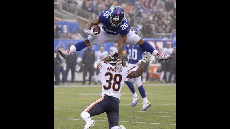 New York Giants running back Saquon Barkley leaps over Chicago Bears safety Adrian Amos during the second half of an NFL football game on Sunday, December 2, in East Rutherford, New Jersey. The Giants won the game 30-27 in overtime.