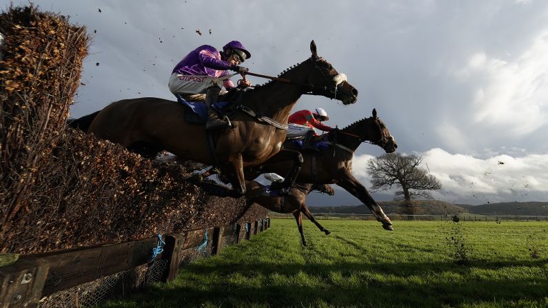 Horses and their jockeys clear a fence in the back straight at Taunton Racecourse on Thursday, November 29, in Taunton, England.