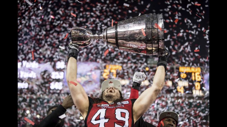 Calgary Stampeders' Alex Singleton hoists the Grey Cup after the Stampeders defeated the Ottawa Redblacks during the Canadian Football League Grey Cup in Edmonton, Alberta, on Sunday, November 25.