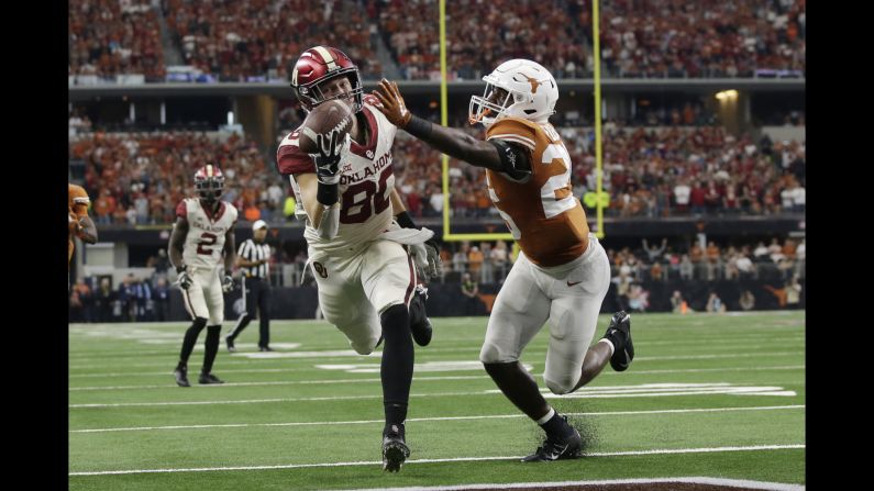 Oklahoma Sooners tight end Grant Calcaterra catches a touchdown pass against Texas Longhorns defensive back B.J. Foster in the fourth quarter of the Big 12 championship game at AT&T Stadium in Arlington, Texas. 