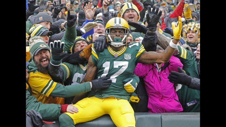 Green Bay Packers wide receiver Davante Adams celebrates with fans after scoring a touchdown against the Arizona Cardinals during the first half of an NFL football game at Lambeau Field in Green Bay, Wisconsin, on Sunday, December 2. Green Bay lost the game 17-20, prompting the firing of head coach Mike McCarthy.