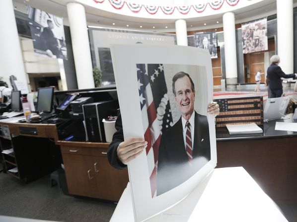 A volunteer at Bush's presidential library prepares posters on December 1.