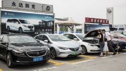 People look at a General Motors Co. (GM) Buick vehicles sitting parked outside a car dealership in Shanghai, China, on Sunday, July 8, 2018. The long threatened trade war escalated just after midnight in Washington on July 6 when the U.S. imposed tariffs on $34 billion of Chinese imports and Beijing immediately said it would be forced to retaliate. Photographer: Qilai Shen/Bloomberg via Getty Images