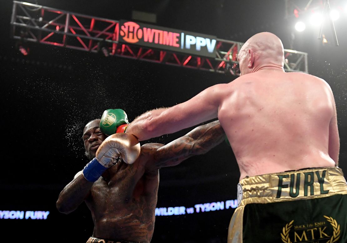 Tyson Fury punches Deontay Wilder in the fifth round.