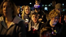 People watch as a menorah is lighted outside the Tree of Life Synagogue on the first night of Hanukkah, Sunday, Dec. 2, 2018 in the Squirrel Hill neighborhood of Pittsburgh. A gunman shot and killed 11 people while they worshipped Saturday, Oct. 27, 2018 at the temple. (AP Photo/Gene J. Puskar)