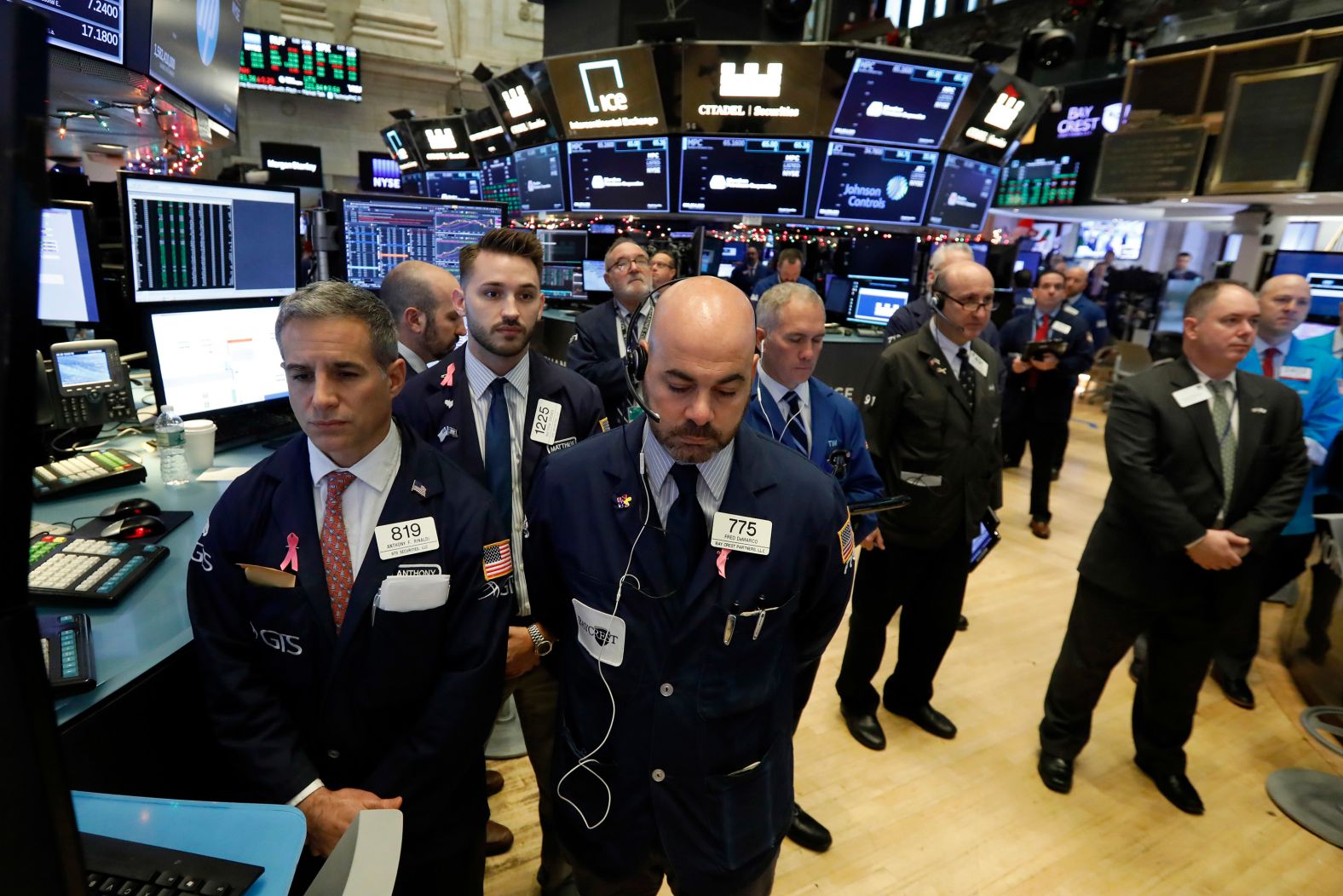 Traders on the floor of the New York Stock Exchange pause for a moment of silence on December 3.