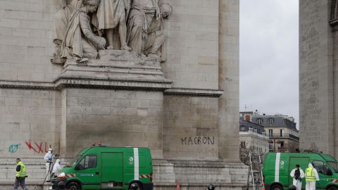 Workers clean grafitti off the Arc de Triomphe.