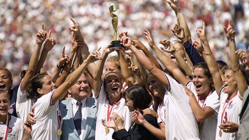 PASADENA, CALIFORNIA - JULY 10:  Captian Carla Overbeck #4 of the US Women's Soccer Team raises the World Cup Trophy, as the team celebrates their victory over Team China in the Championship match of the FIFA Women's World Cup at the Rose Bowl on July 10, 1999 in Pasadena, California.  Team USA defeated Team China 5-4 in sudden death after two overtimes.  (Photo by Harry How/Getty Images)