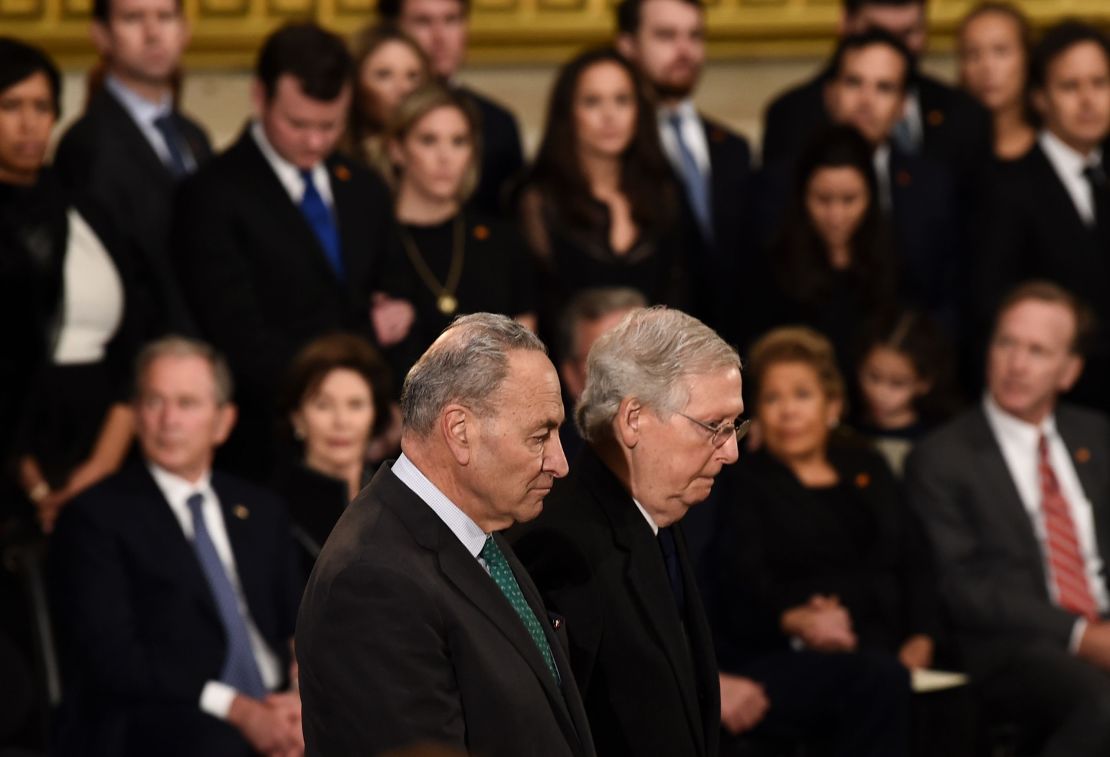 Senate Majority Leader Mitch McConnell, at right, and US Senate Minority Leader Chuck Schumer, at left, pay their respects during the service for former US President George H.W. Bush as he lies in state at the US Capitol during a ceremony in Washington, DC. (Photo by Brendan SMIALOWSKI / AFP)