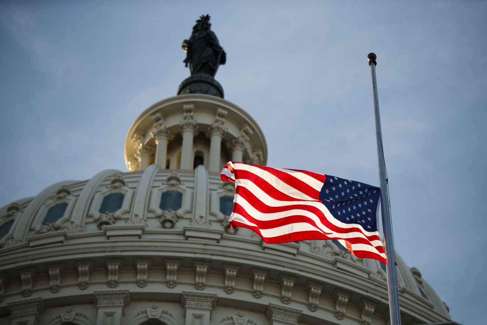 The American flag flies at half-staff at the US Capitol on December 3.