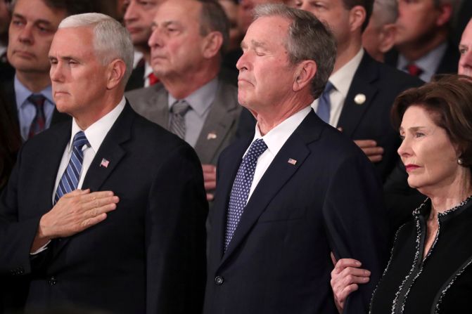 From left, Vice President Mike Pence, former President George W. Bush and former first lady Laura Bush watch the late President's casket arrive at the US Capitol rotunda on Monday, December 3.