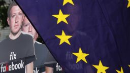 Cutouts of Facebook Inc. Chief Executive Officer Mark Zuckerberg stand beside a European Union (EU) flag during a protest outside the Berlaymont building ahead of his testimony before lawmakers in Brussels, Belgium, on Tuesday, May 22, 2018. Zuckerberg will tout the companys investment in Europe and again take responsibility for privacy failures, according to testimony prepared for an appearance Tuesday in front of the regions parliament. Photographer: Dario Pigantelli/Bloomberg via Getty Images
