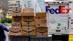 A worker pushes Amazon.com Inc. packages in front of a FedEx Corp. delivery truck in New York, U.S., on Monday, Nov. 26, 2018. Americans spent $50.6 billion online this month through Sunday, a 20 percent increase from a year ago and spearheaded by a 24 percent surge to $6.2 billion on Black Friday, according to Adobe Analytics. Cyber Monday is expected to add another $7.8 billion -- an 18 percent year-over-year gain for that day. Photographer: Christopher Lee/Bloomberg via Getty Images