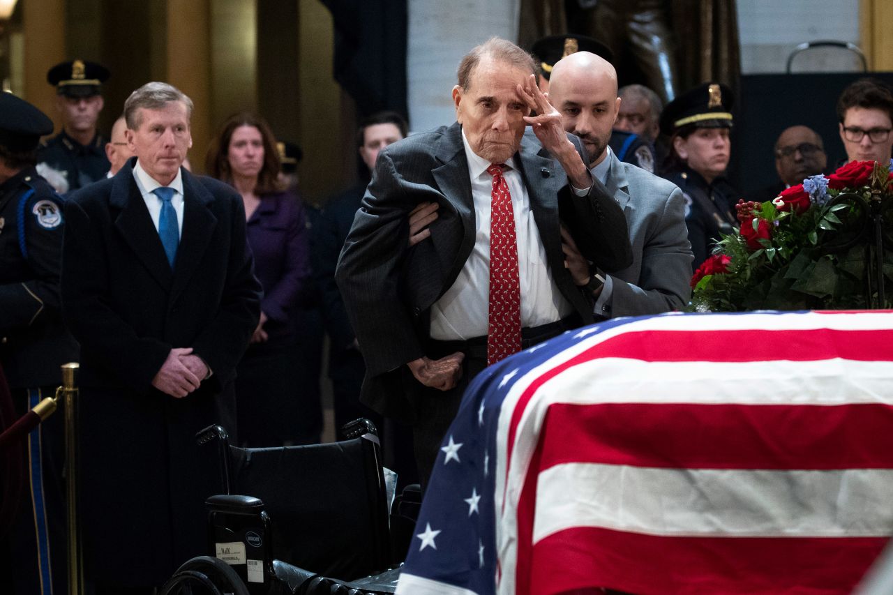 Former US Sen. Bob Dole salutes Bush's casket as he is helped out of his wheelchair on Tuesday, December 4. Bush was lying in state at the Capitol rotunda.