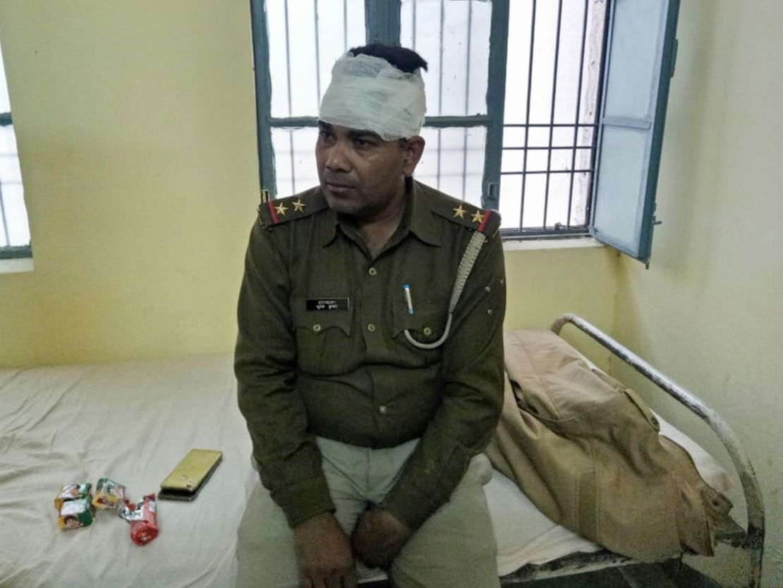 An Indian policeman looks on after receiving treatment for a head injury following reports of mob violence at Chingravati village in Bulandshahr, on December 3, 2018.