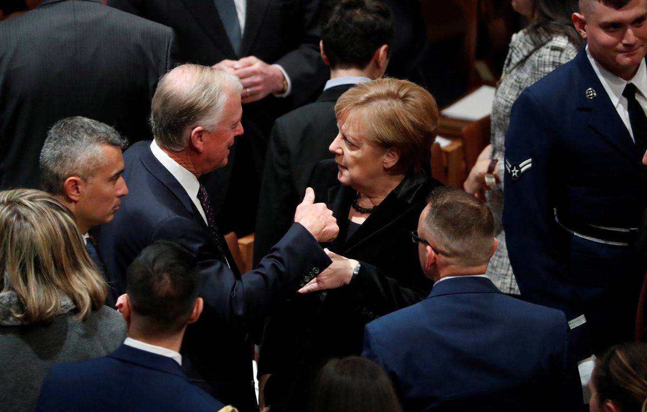 Merkel talks with Dan Quayle, who was vice president under Bush.