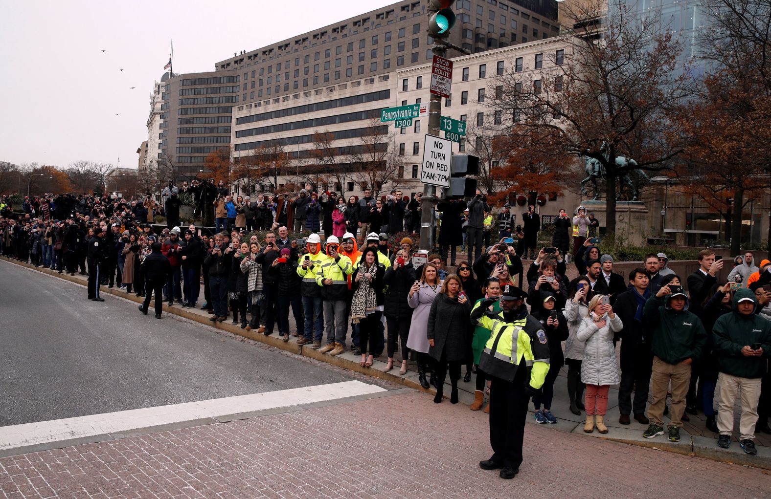 People watch as Bush's hearse passes Freedom Plaza in Washington on the way to the funeral.