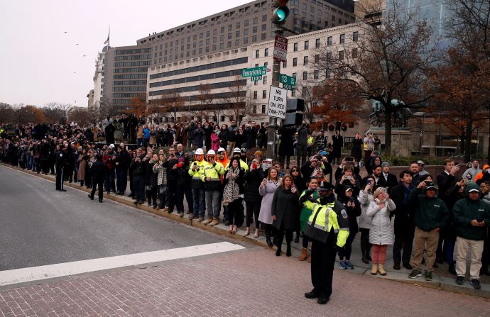 People watch as Bush's hearse passes Freedom Plaza in Washington on the way to the funeral.