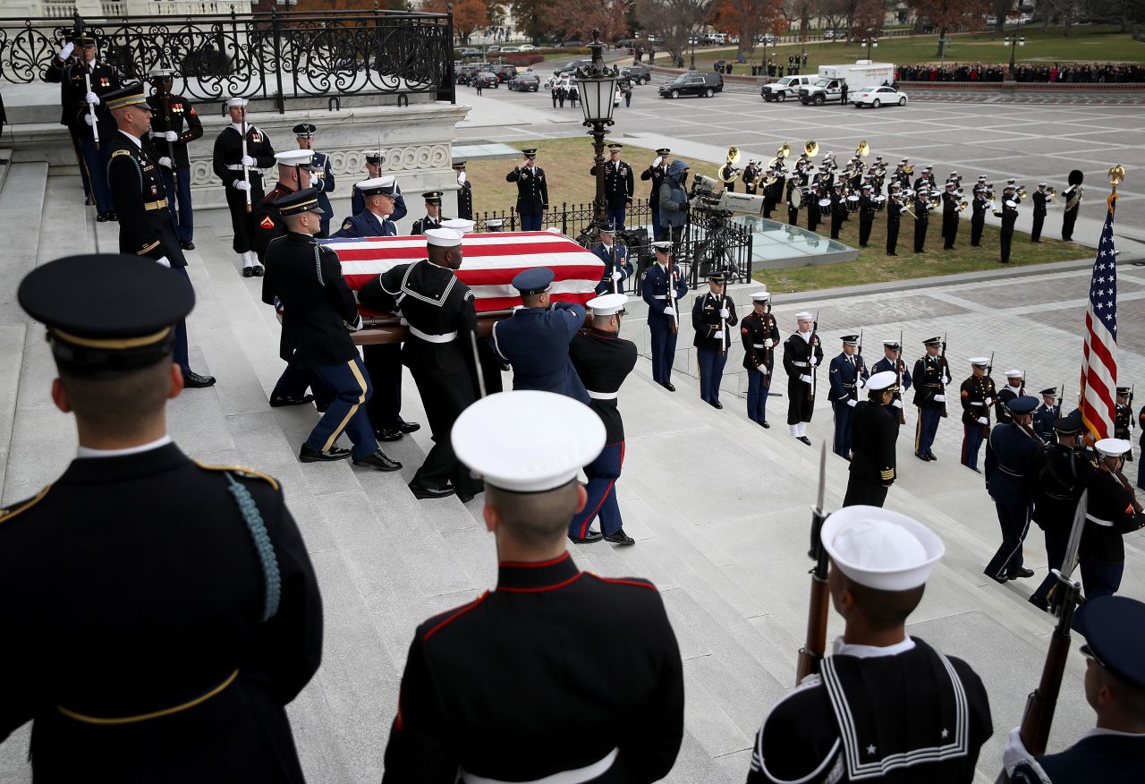 A military honor guard carries Bush's casket down the steps of the US Capitol. 